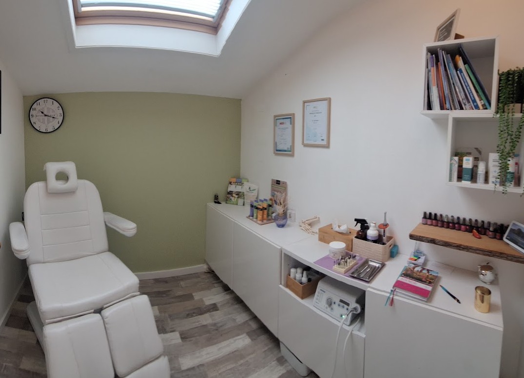 De behandelkamer: de witte pedicurestoel voor de groene wand, met de werkplek en producten ernaast